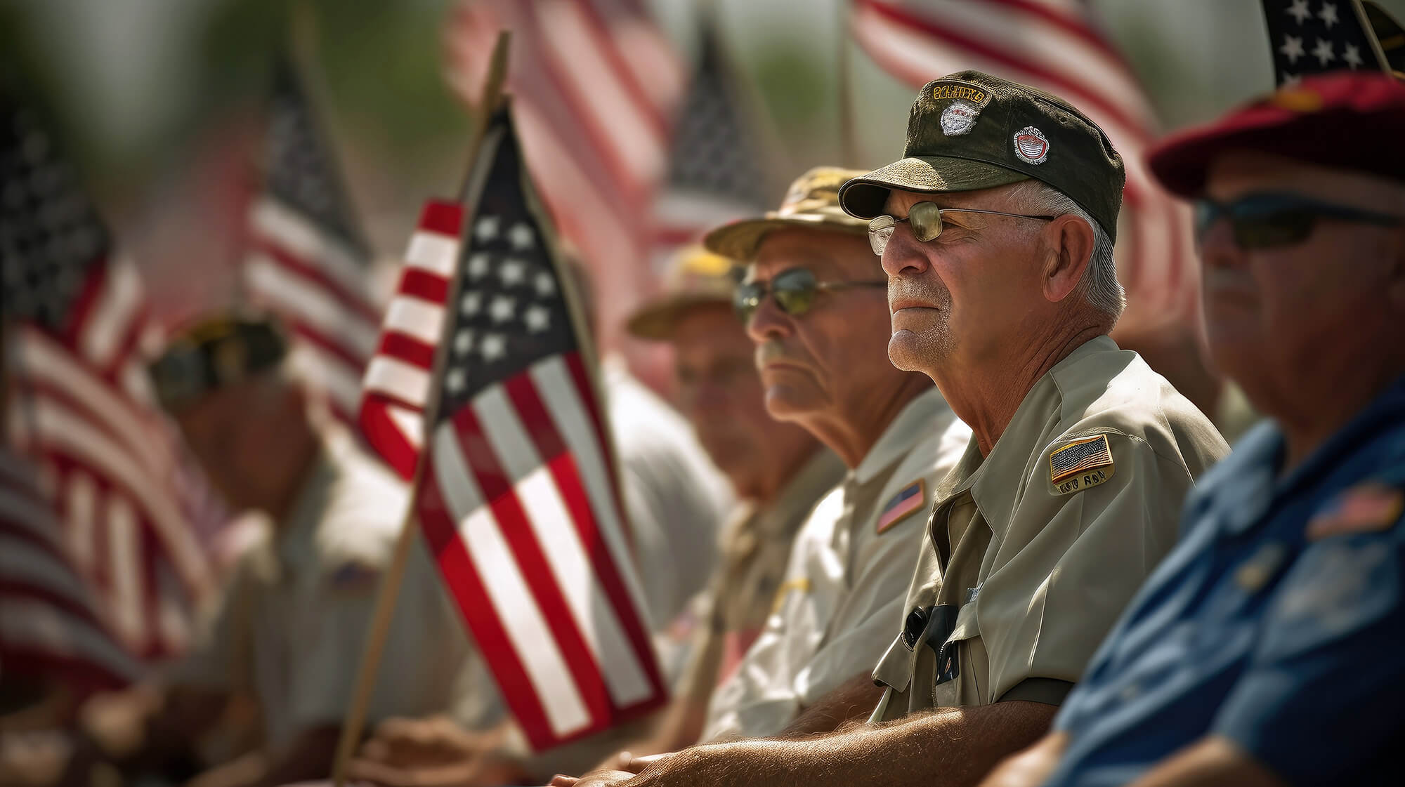 Veterans sitting in their uniforms with American Flags